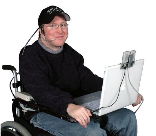 A man using puff n' sip adaptive technology to control a keyboard